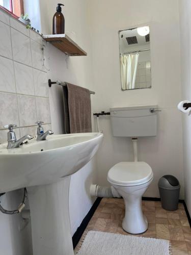 a white bathroom with a sink and a toilet at Zoete Inval Travelers Lodge-Backpacker Loft in Hermanus