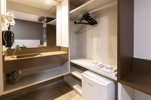a bathroom with a sink and a mirror at Hotel Palmas Executivo in Balneário Camboriú