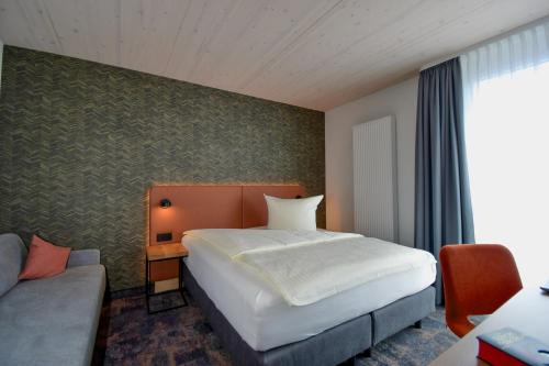 a hotel room with a bed and a couch at iQ-Hotel Ulm in Ulm
