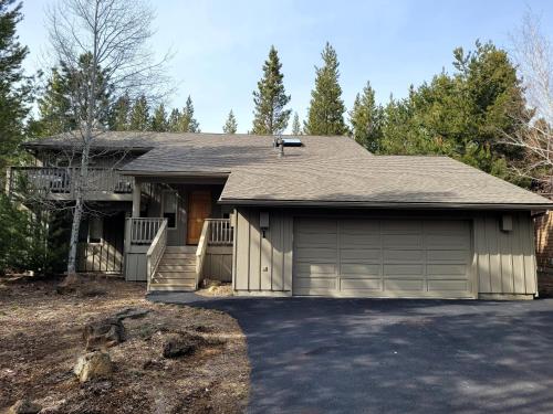 a house with a garage with a driveway at 1 Fifteenth Tee Lane in Sunriver