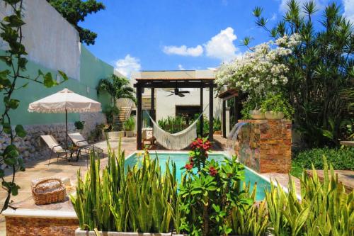 a swimming pool in a garden with a pavilion at Casa Magu Merida in Mérida
