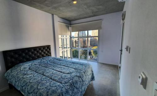 a bedroom with a bed and a large window at Espectacular departamento en Palermo in Buenos Aires