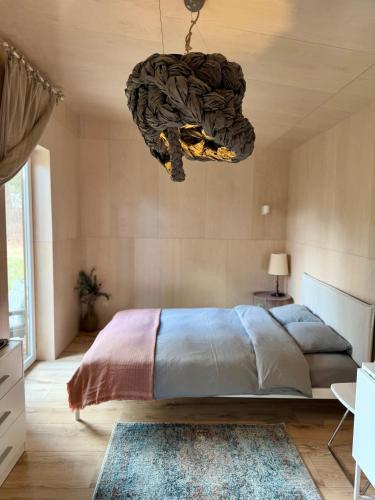 a bedroom with a large bed and a chandelier at D a c h a in Ventspils