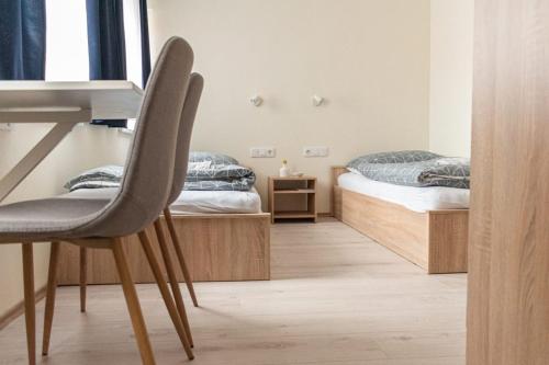 two beds in a room with a desk and a chair at Randevú Panzió in Sopron