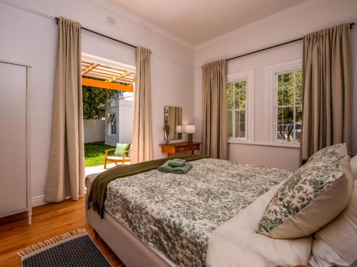 a bedroom with a bed and a large window at House Erens By Die Bos in Stellenbosch