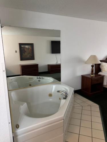 a large white bath tub in a room at Garrison Inn and Suites in Garrison