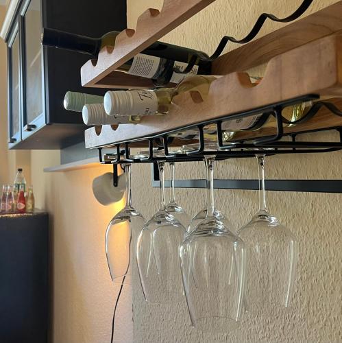 a bunch of wine glasses hanging from a rack in a kitchen at Hochwertige Wohnung im EG- Meißen zum Genießen in Meißen