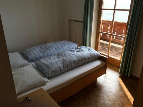 a bed sitting in a room with a window at Fallerhof in Villnoss