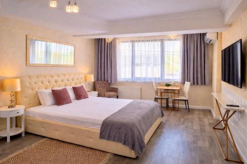a bedroom with a large bed and a living room at Brater Luxury in Bucharest