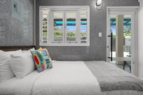 a bedroom with a white bed with a window at La Balandra Luxury Stays in Dorado