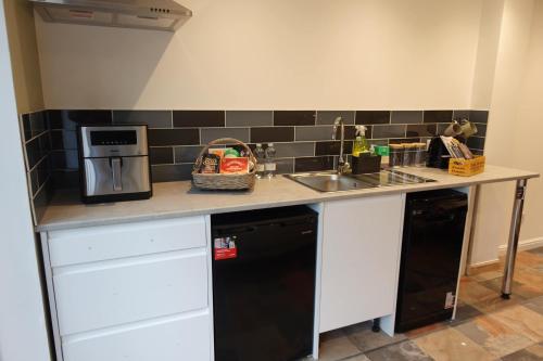 a kitchen counter with a sink and a microwave at Modern Bicester Studio Self-Contained with Parking in Bicester