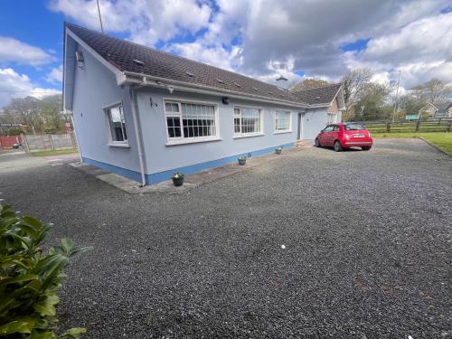 a blue house with a car parked in a driveway at Countryside Family Home in Balrath