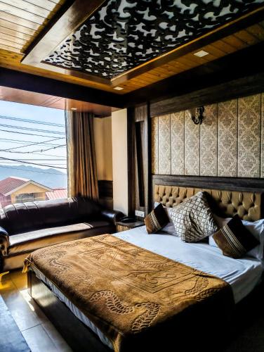 a bedroom with a large bed with a large window at Golden Glow Stays in Shimla