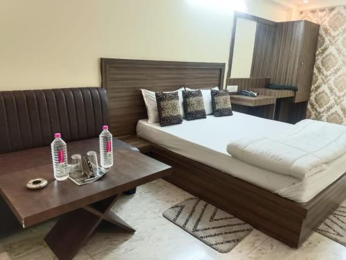 a bedroom with a bed and a table with water bottles at hotel atithi palace in Jabalpur