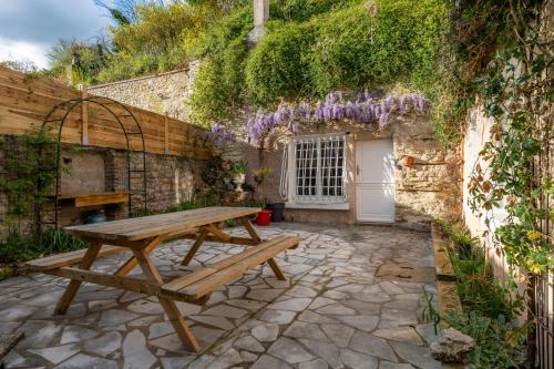 a wooden picnic table in the courtyard of a house at Maison semi-troglo - Proche Chenonceaux - Amboise - La Caburoche de Charlemagne in Civray-de-Touraine
