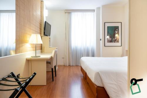 a hotel room with a bed and a desk with a computer at Hotiday Brindisi Garibaldi in Brindisi