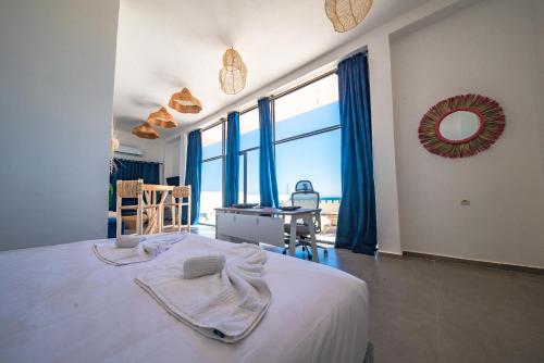 a bedroom with a large bed with blue curtains at Loft Beachfront Bungalow with Private Beach in Dakhla