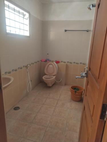 a bathroom with a toilet and a sink at Serenity Villa in Mysore