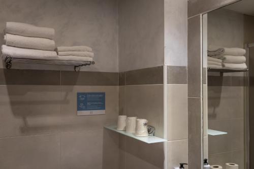 a bathroom with towels on shelves and a mirror at Alda Centro Palencia in Palencia
