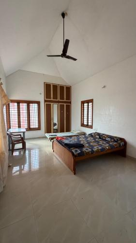 a large bedroom with a bed and a ceiling fan at Serenity Villa in Mysore