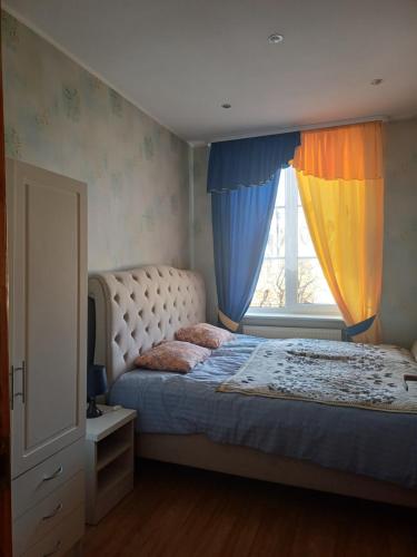a bedroom with a bed and a window with curtains at MERE Apartment in Sillamäe