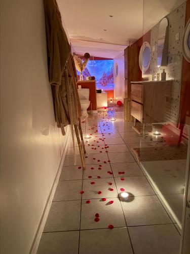 a living room with a tiled floor with red rose petals at L Antre du Désir in Saint-Léonard