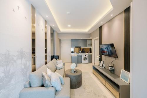 a living room with a couch and a tv at Amalea at Benson Pakuwon Mall in Surabaya
