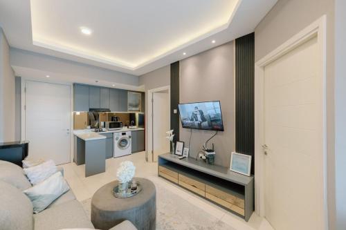 a living room with a couch and a tv at Amalea at Benson Pakuwon Mall in Surabaya