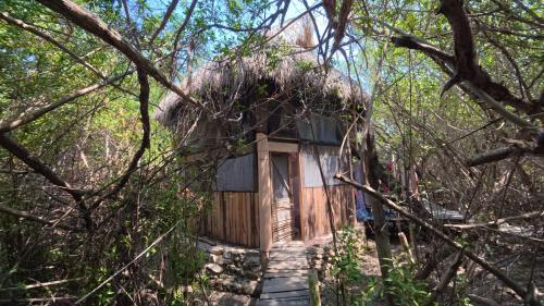 a cabin in the woods with a thatched roof at Mariposa - Casa Corazon Mazunte in Mazunte