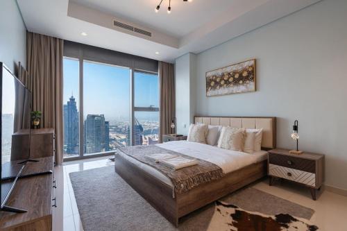 a bedroom with a large bed and a large window at Near Dubai Mall PoolAccess SunSetView KingBed in Dubai