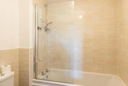 a bathroom with a shower and a bath tub at Quiet Three-Bedroom Home in Stewartby with Ensuite and Workspace in Bedford
