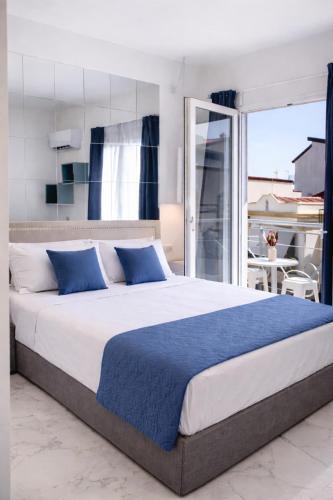 a large bed with blue pillows in a bedroom at Il Vicoletto B&B - In pieno centro in Cirò Marina