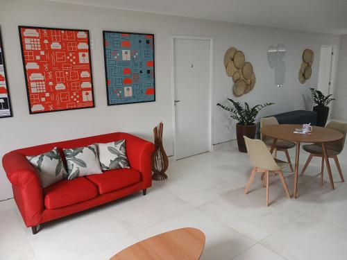 a living room with a red couch and a table at COLOFT - Quarto 4 Hospedagem rápida ou Sala de reunião in Anápolis