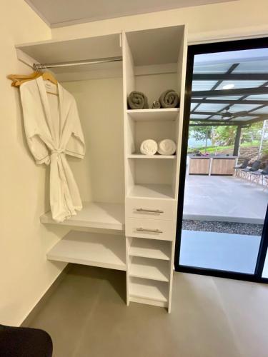 a closet with white shelves and a mirror at Casa Eucalipto in Chachagua