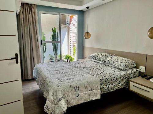 a bedroom with a bed and a window at Mello's House in Curitiba