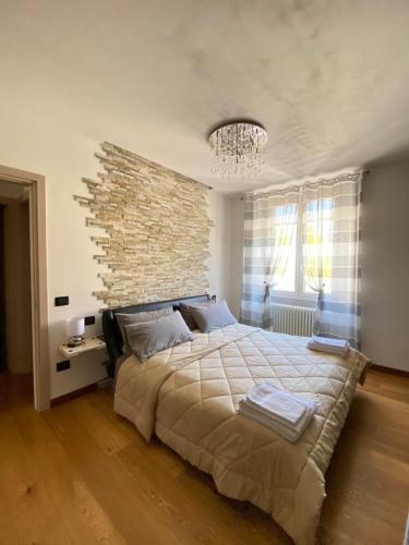 a bedroom with a large bed with a brick wall at Residenza Basilica in Tirano