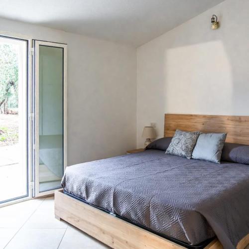 a bedroom with a bed and a sliding glass door at Domo Appeddu in Orosei