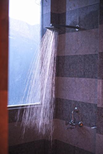 a stream of water is coming out of a shower at Bell Mount Mussoorie Hill view Hotel in Mussoorie