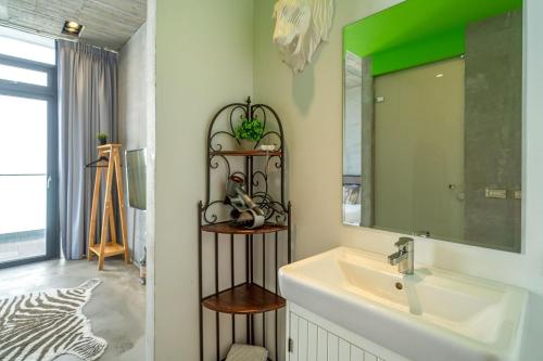 a bathroom with a sink and a mirror at 蘆薈villa清水模派對k歌BBQ麻將包棟 in Wujie