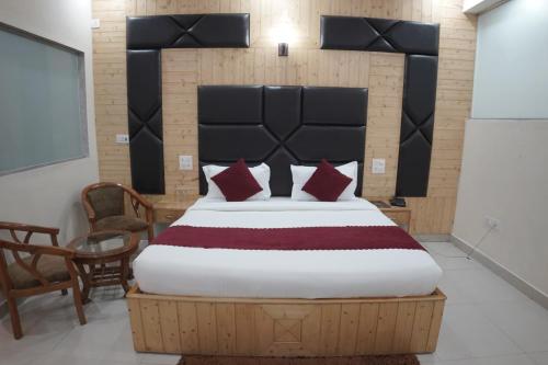 a bedroom with a large bed with red pillows at Bell Mount Mussoorie Hill view Hotel in Mussoorie