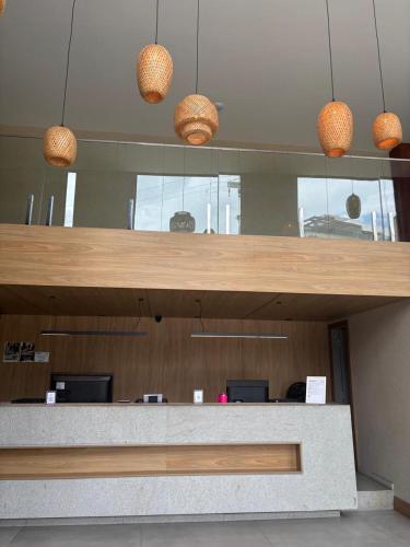 an office with a reception counter with baskets on the ceiling at Sereno Hotel in Cabo Frio