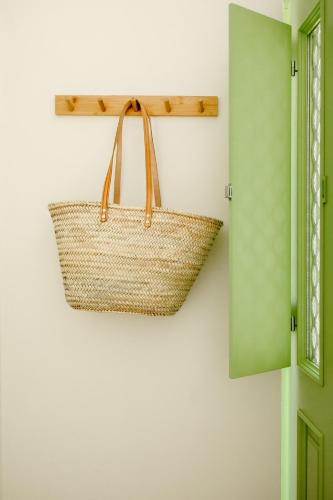 a basket hanging on a wall next to a door at Casa do Mar - Casas do Levante in Olhão