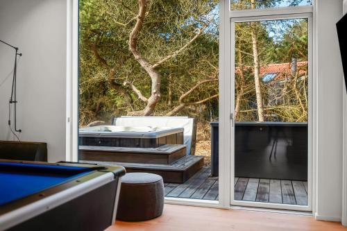 a room with a pool table and a sliding glass door at Feriehus 1161 in Ringkøbing