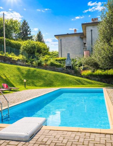 a swimming pool in front of a house at Residenz Ai Ronchi in Germignaga