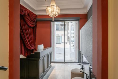 a hallway with red walls and a chandelier at BYPILLOW Callao in Madrid