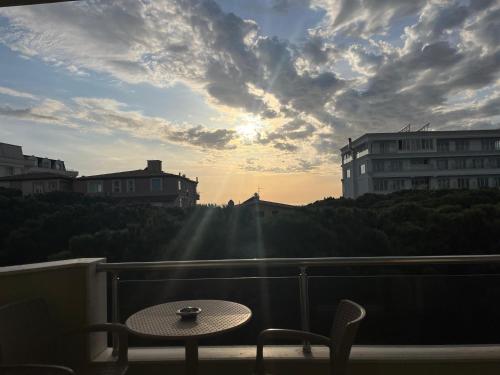 a table and chairs on a balcony with a sunset at Rezidenca Kalter Durres in Golem
