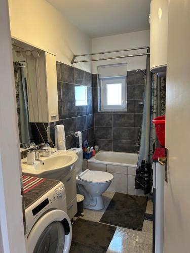 a bathroom with a sink and a toilet and a tub at Kuća za odmor - Snowwhite in Smoković