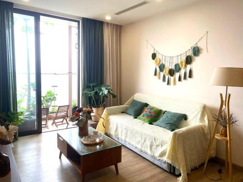 a living room with a couch and a table at Caracole homestay - 2BR with cozy balcony garden in Kim Quan