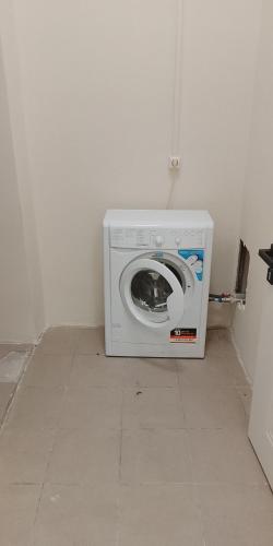a washing machine sitting on the floor in a room at Atom hostel for men in Astana