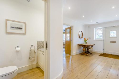 a white bathroom with a toilet and a table at 5 Bed in Walberswick oc-hlwal in Walberswick